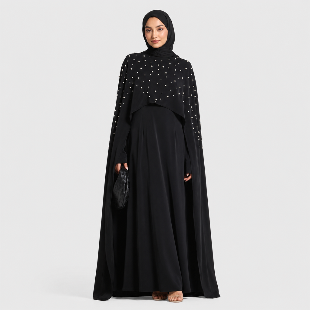 Woman wearing a black outfit with white embellishments on a white background