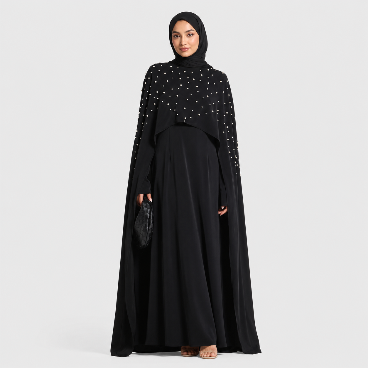 Woman wearing a black outfit with white embellishments on a white background