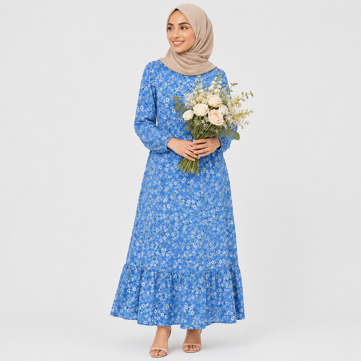 Woman wearing a blue floral dress holding flowers against a white background