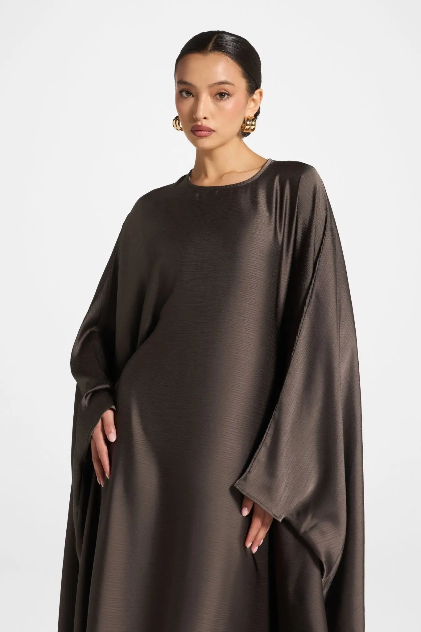 Woman wearing a brown satin dress on a white background