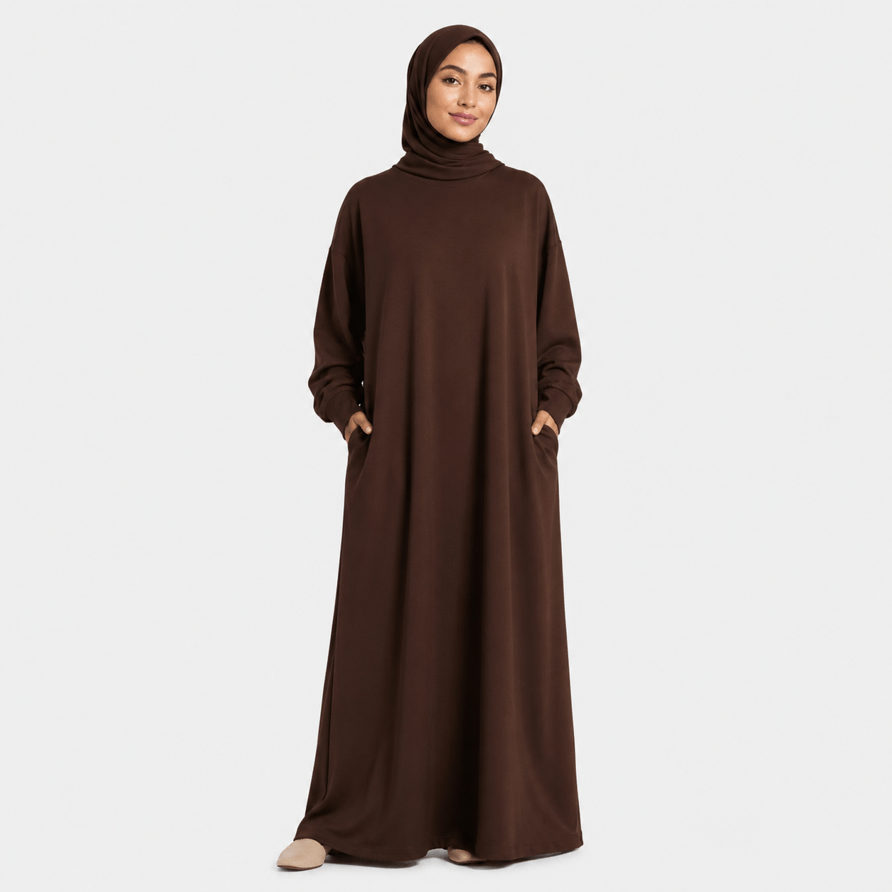 Woman wearing a brown abaya on a white background