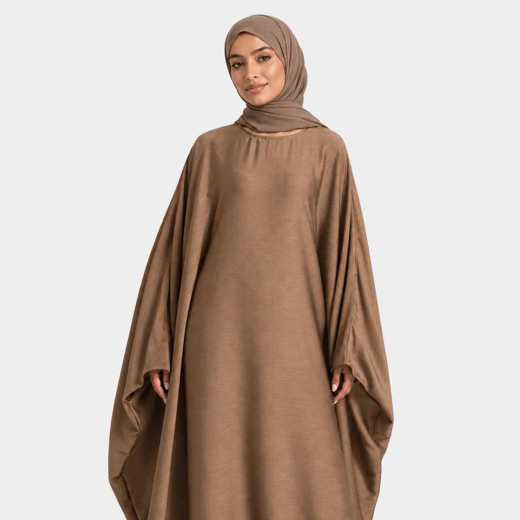 Woman wearing a brown abaya and hijab on a white background