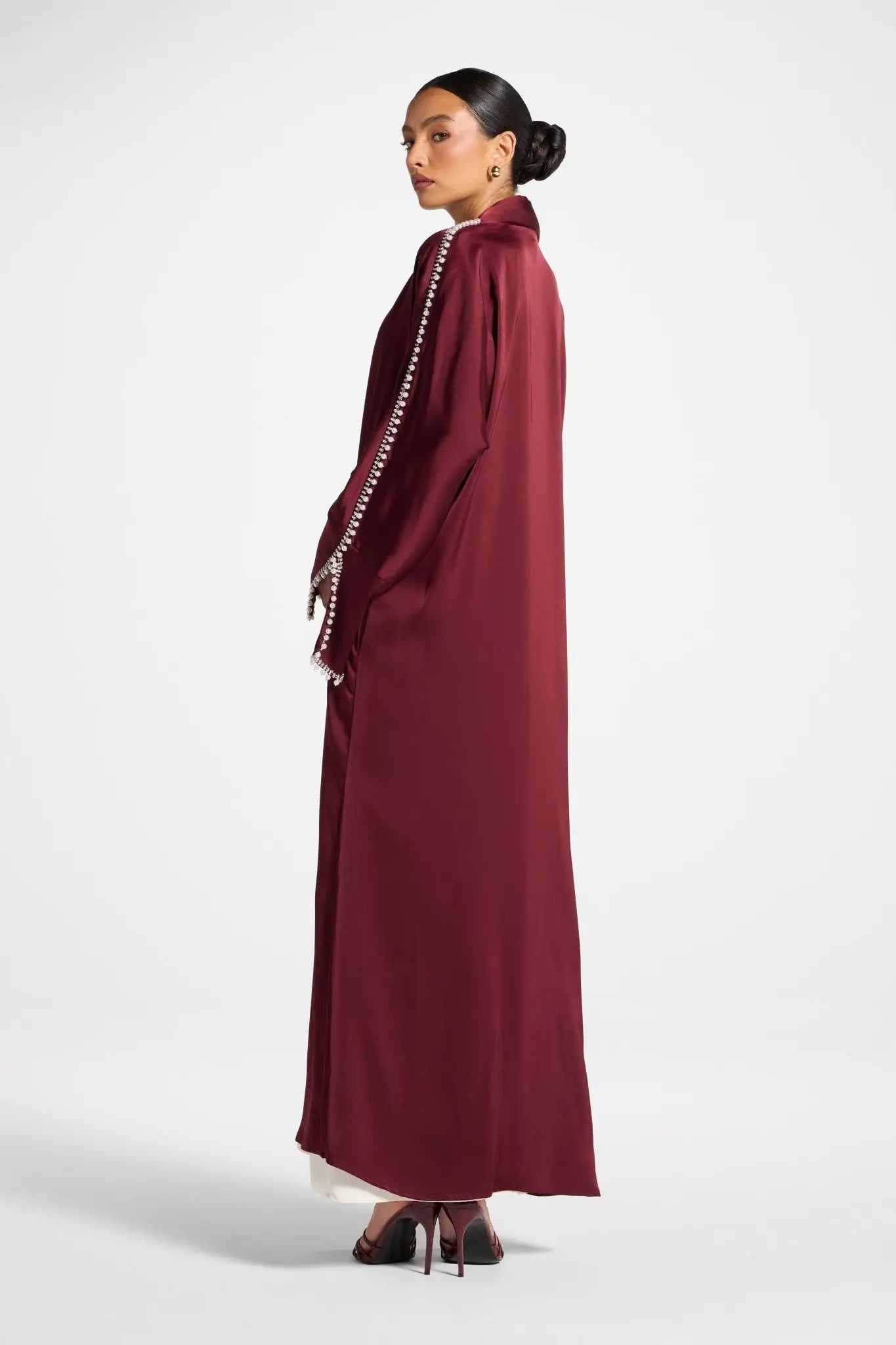 Woman wearing a burgundy dress with a white background
