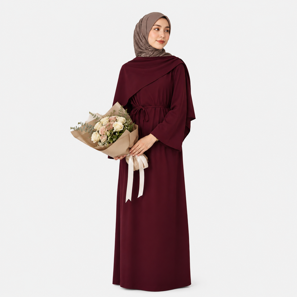Woman in a burgundy dress holding a bouquet of flowers on a white background