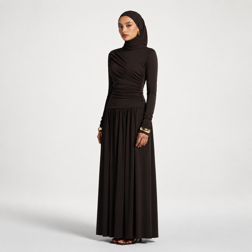 Woman wearing a long black dress with a matching hijab on a white background