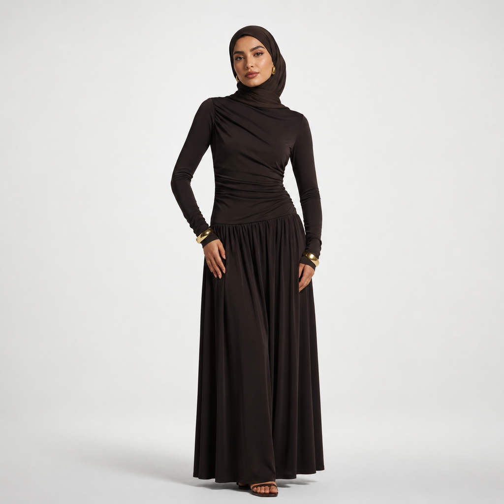 Woman wearing a black long-sleeve dress and hijab on a white background