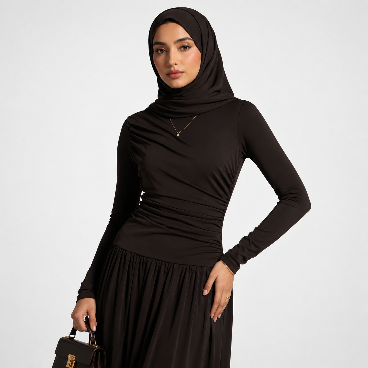 Woman wearing a black hijab and dress on a white background