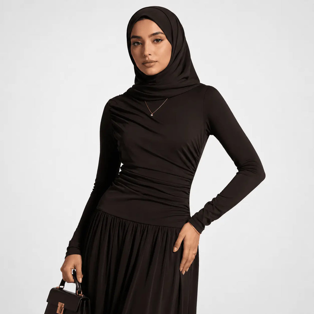 Woman wearing a black hijab and dress on a white background