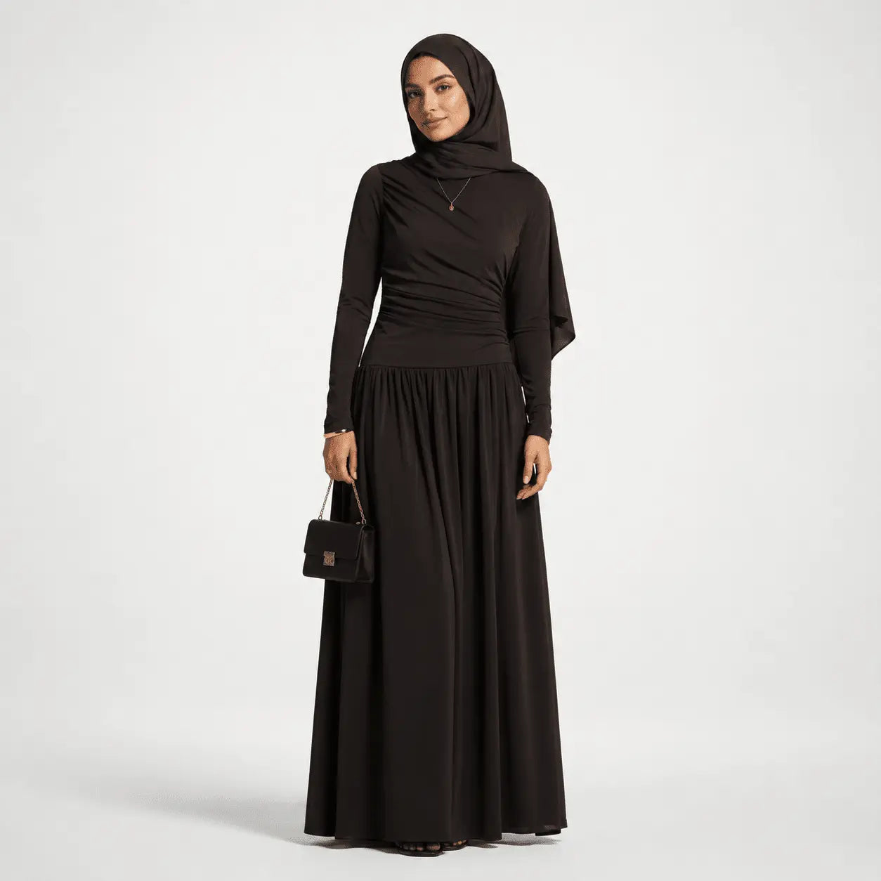 Woman wearing a black outfit with a hijab on a white background
