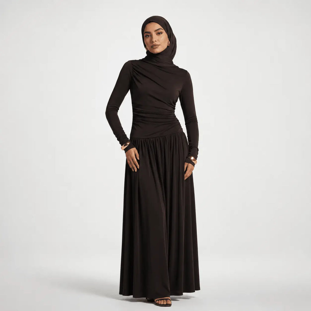 Woman wearing a black long-sleeve top and black hijab on a white background