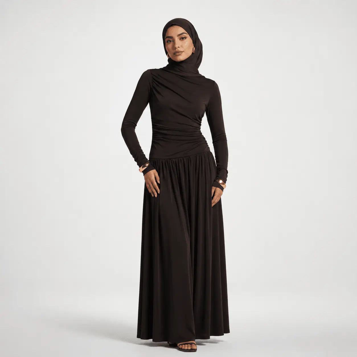 Woman wearing a black long-sleeve top and black hijab on a white background