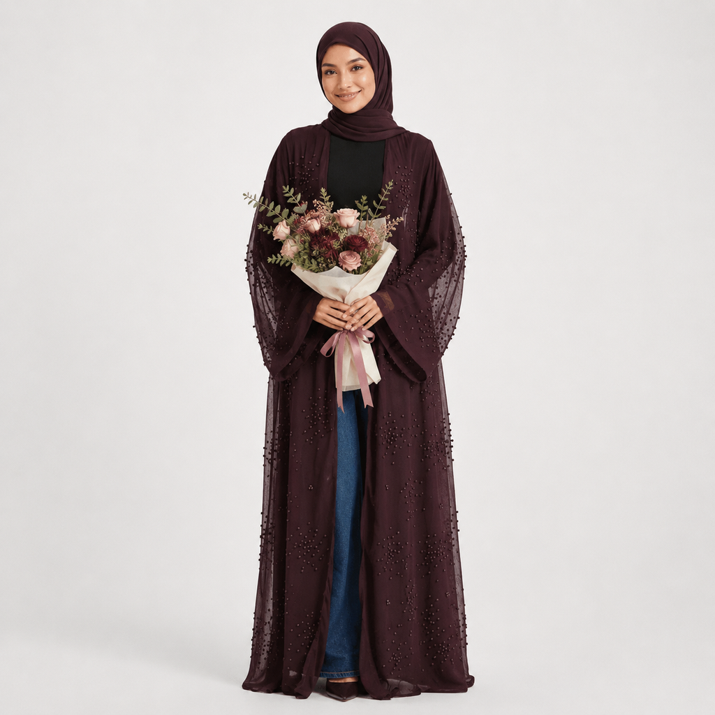 Woman wearing a dark brown abaya holding a bouquet of flowers on a white background