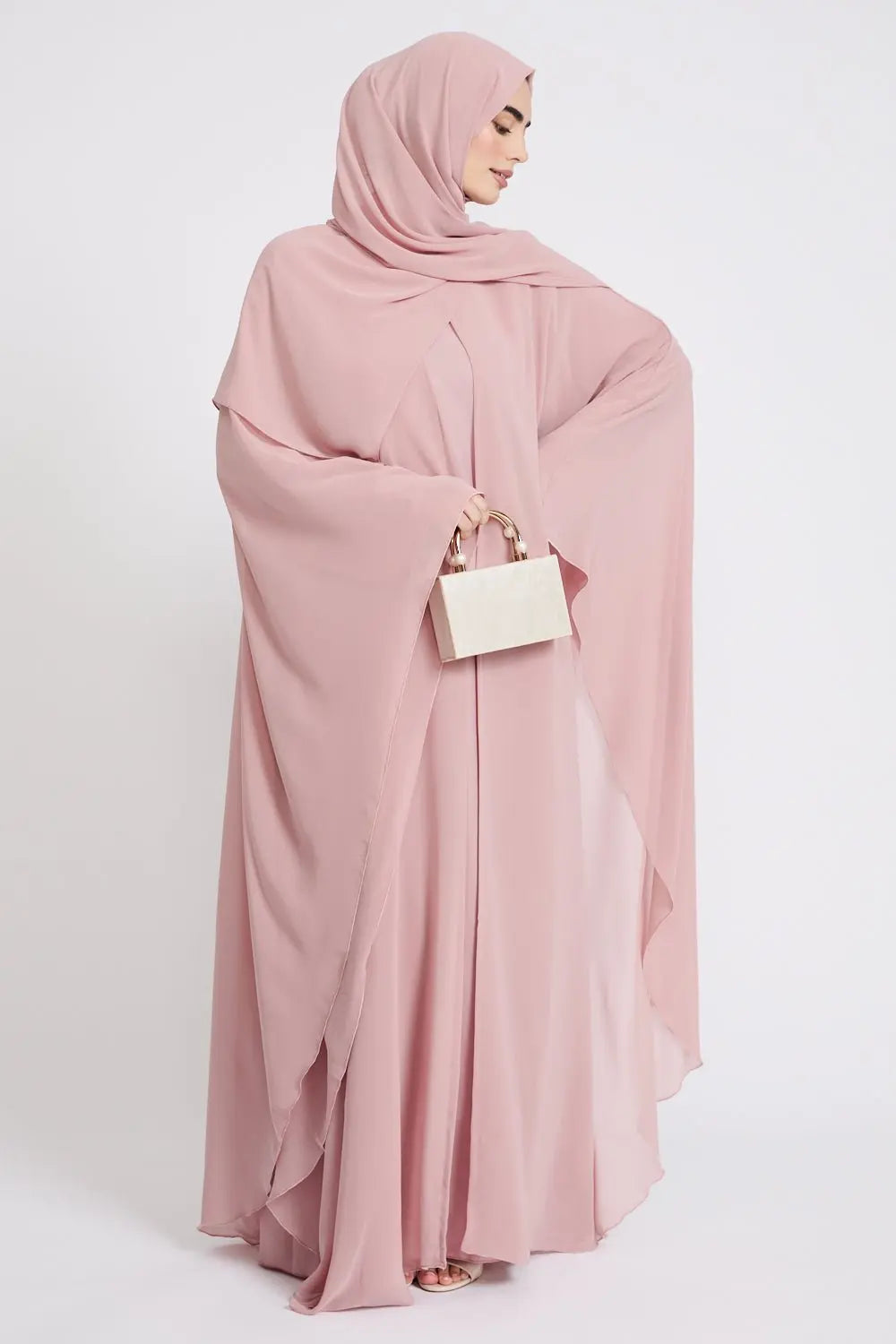Woman wearing a pink hijab and dress on a white background
