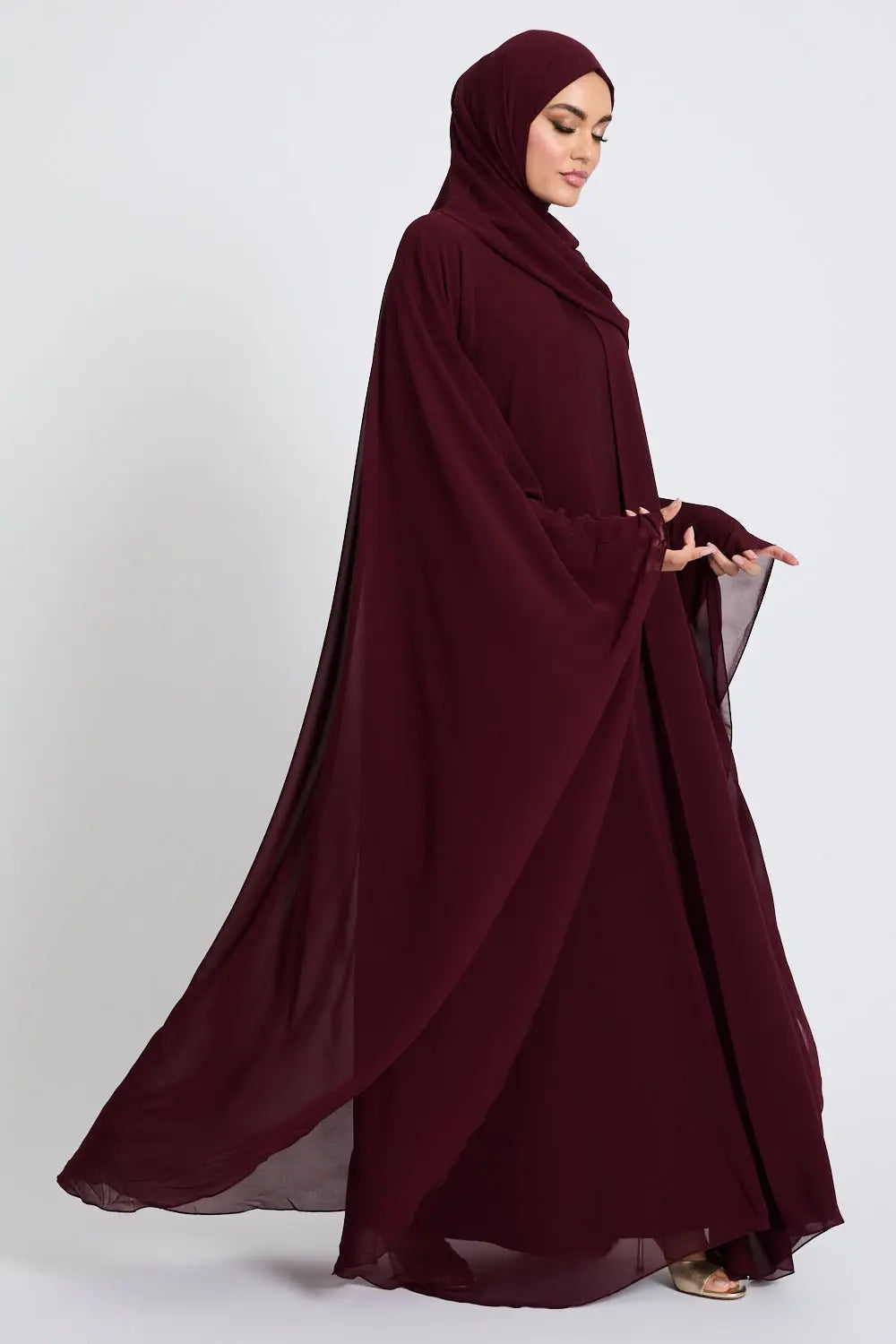 Woman wearing a burgundy abaya on a white background