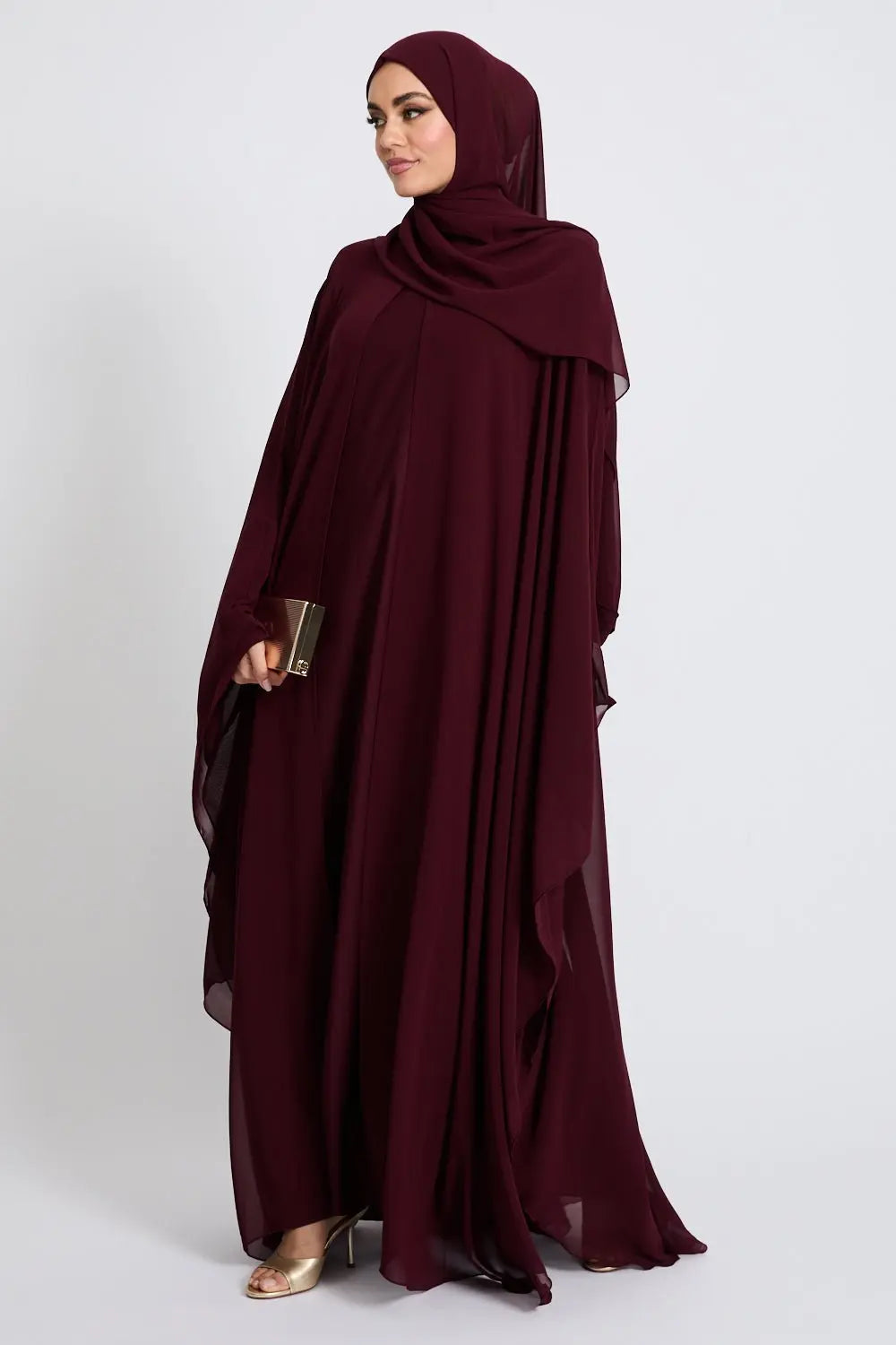 Woman wearing a burgundy abaya on a white background
