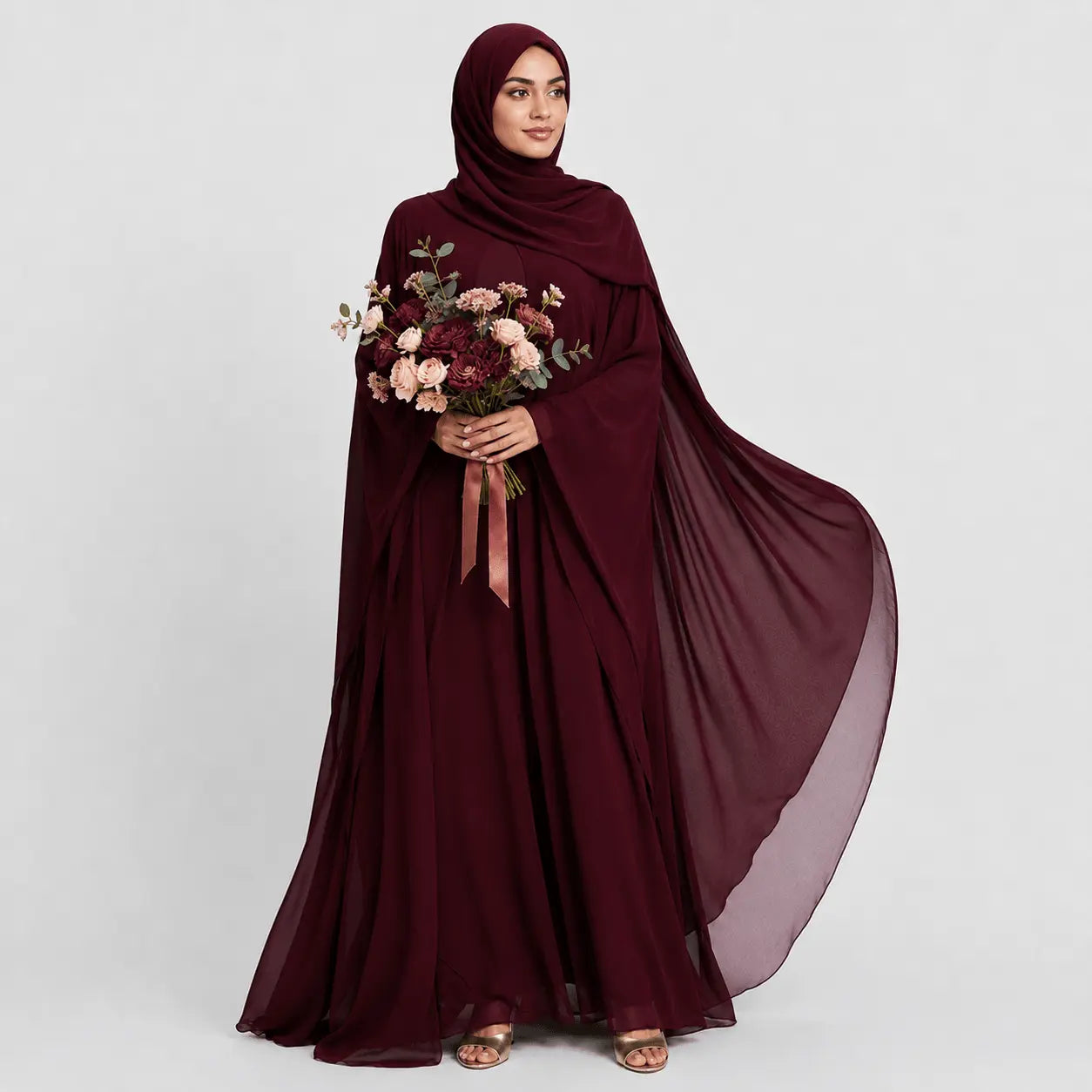 Woman wearing a burgundy abaya holding flowers on a white background