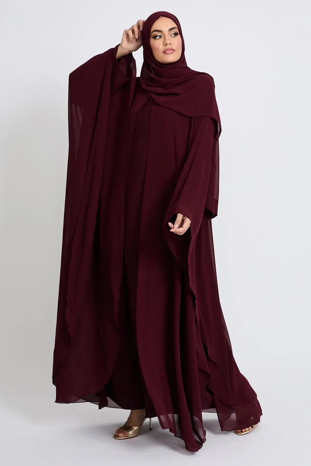Woman wearing a burgundy abaya on a white background