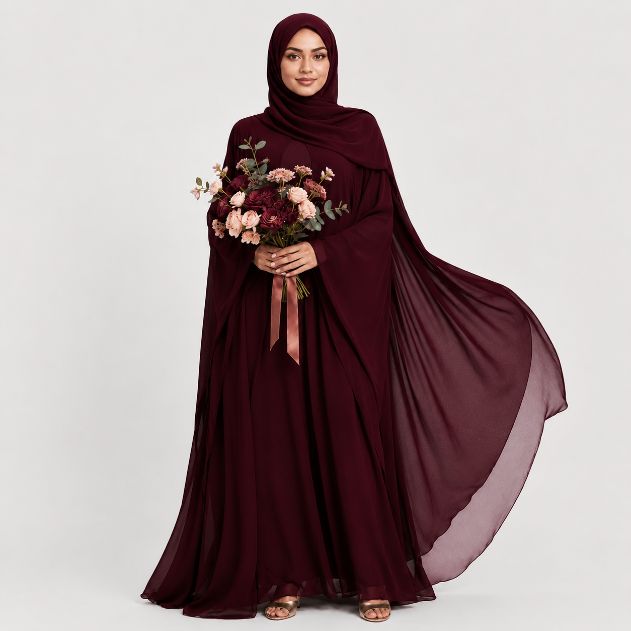 Woman wearing a burgundy abaya holding flowers on a white background