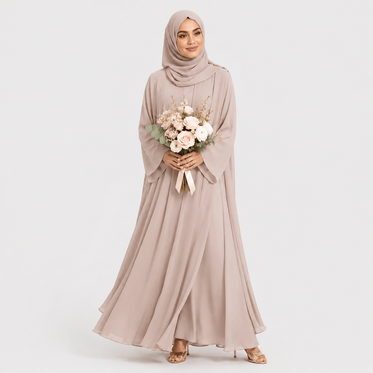 Woman in a long, light-colored dress holding flowers against a plain background
