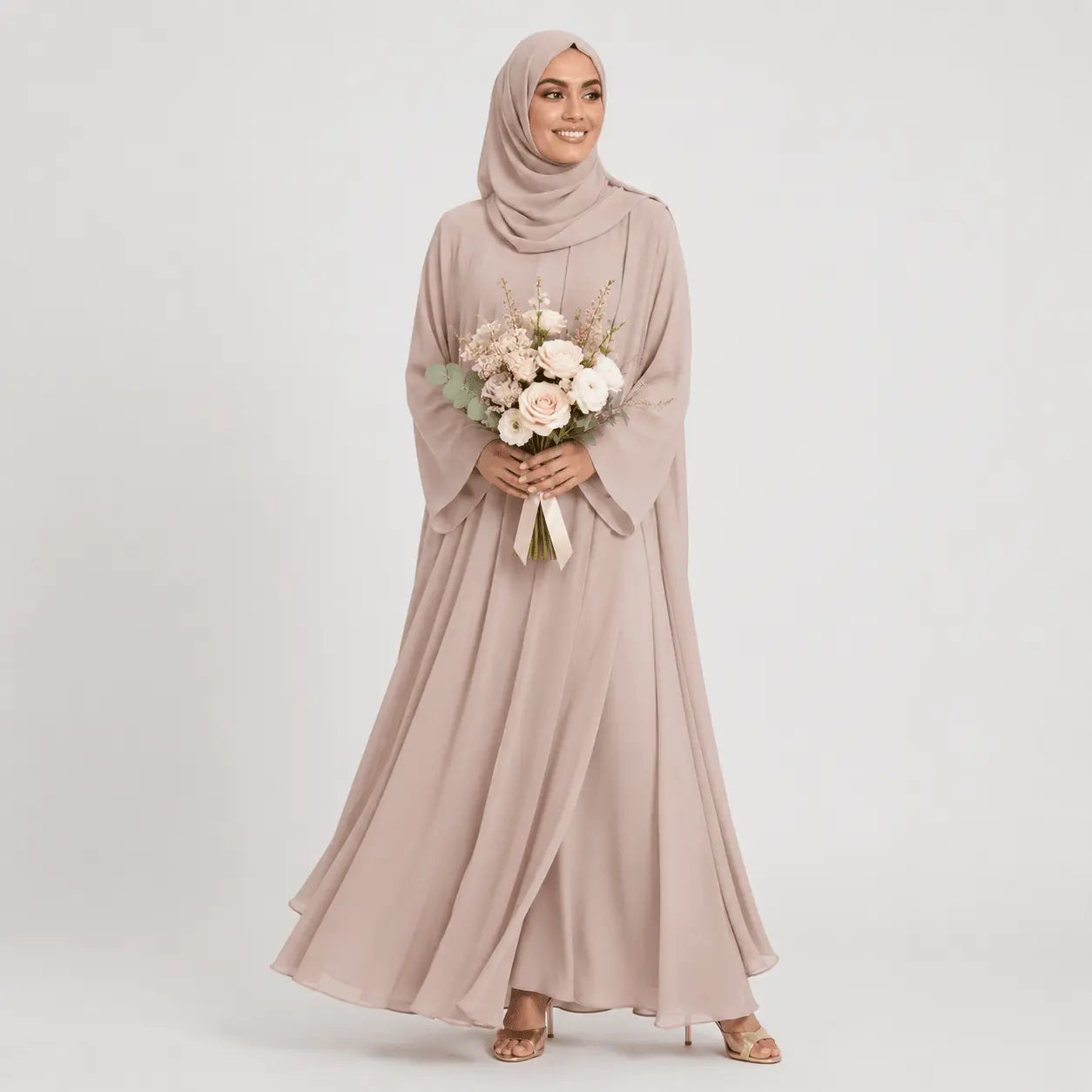 Woman wearing a long, light pink dress and hijab holding flowers on a white background