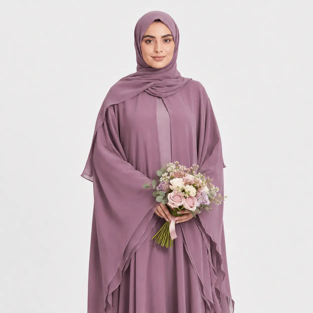 Woman in a mauve abaya holding a bouquet of flowers on a light gray background