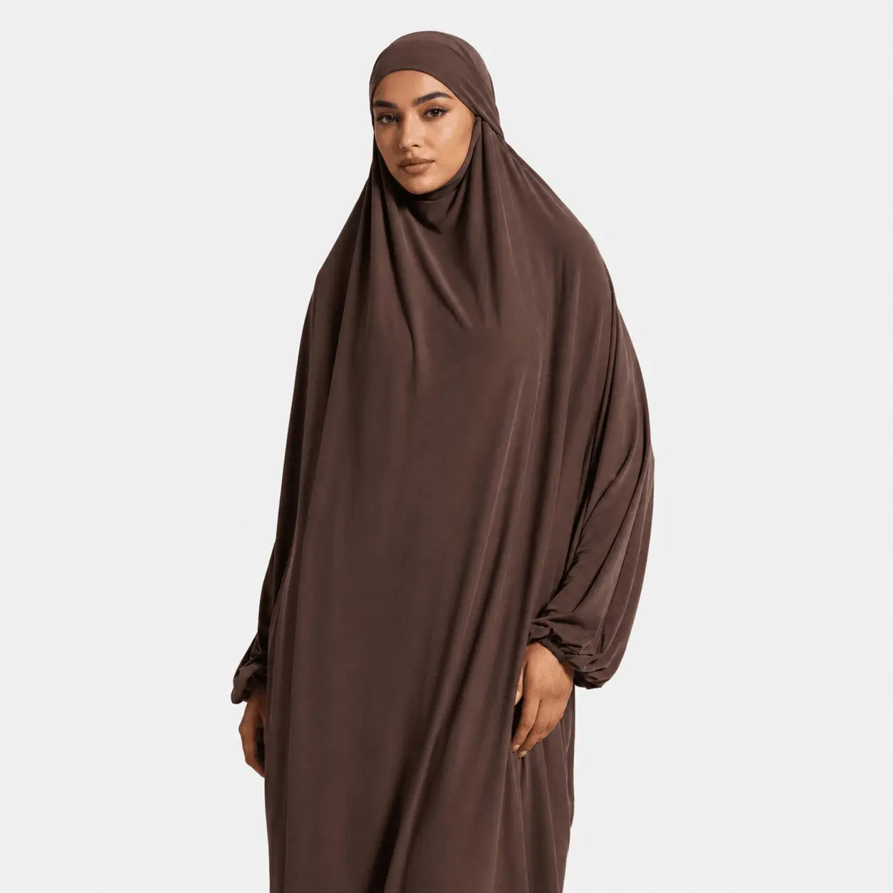 Woman wearing a brown abaya on a white background