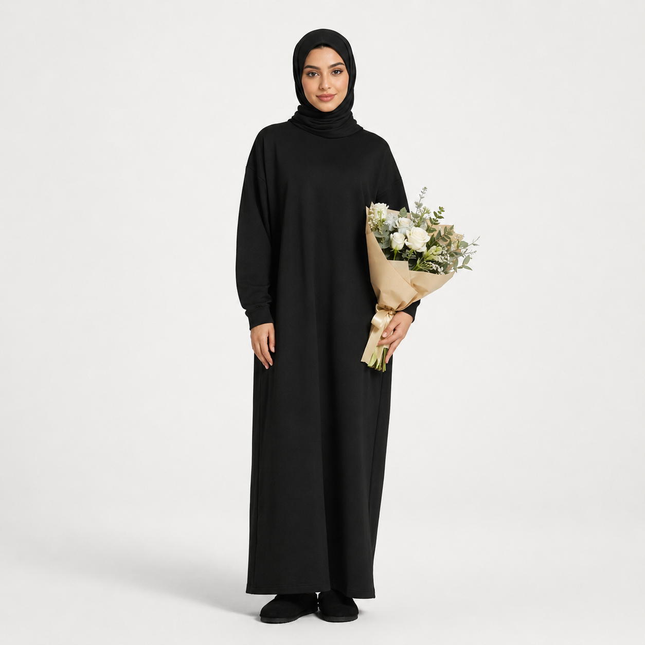 Woman in a black abaya holding a bouquet of flowers on a white background