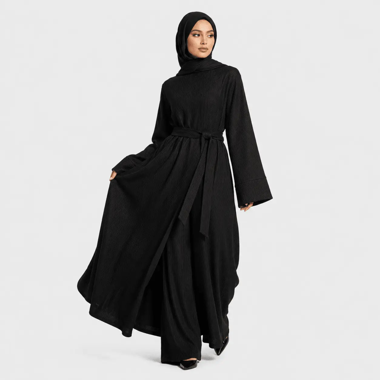 Woman wearing a black abaya on a white background