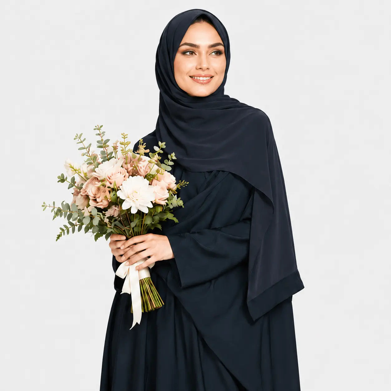 Woman wearing a black hijab and dress holding a bouquet of flowers against a light gray background