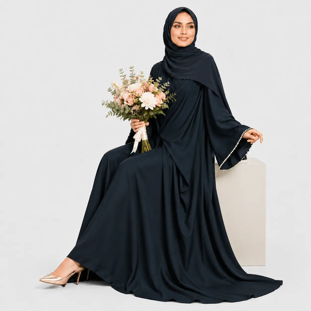 Woman in a black abaya holding flowers on a light gray background