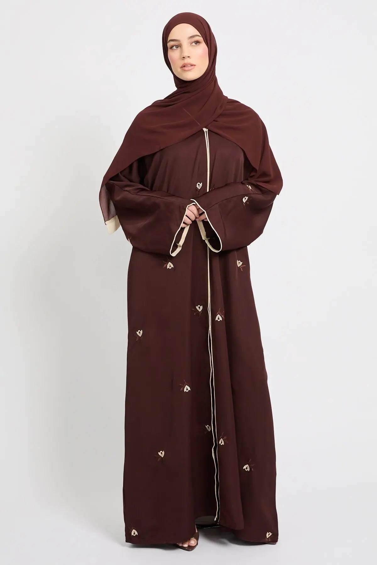 Brown abaya with gold accents on a white background