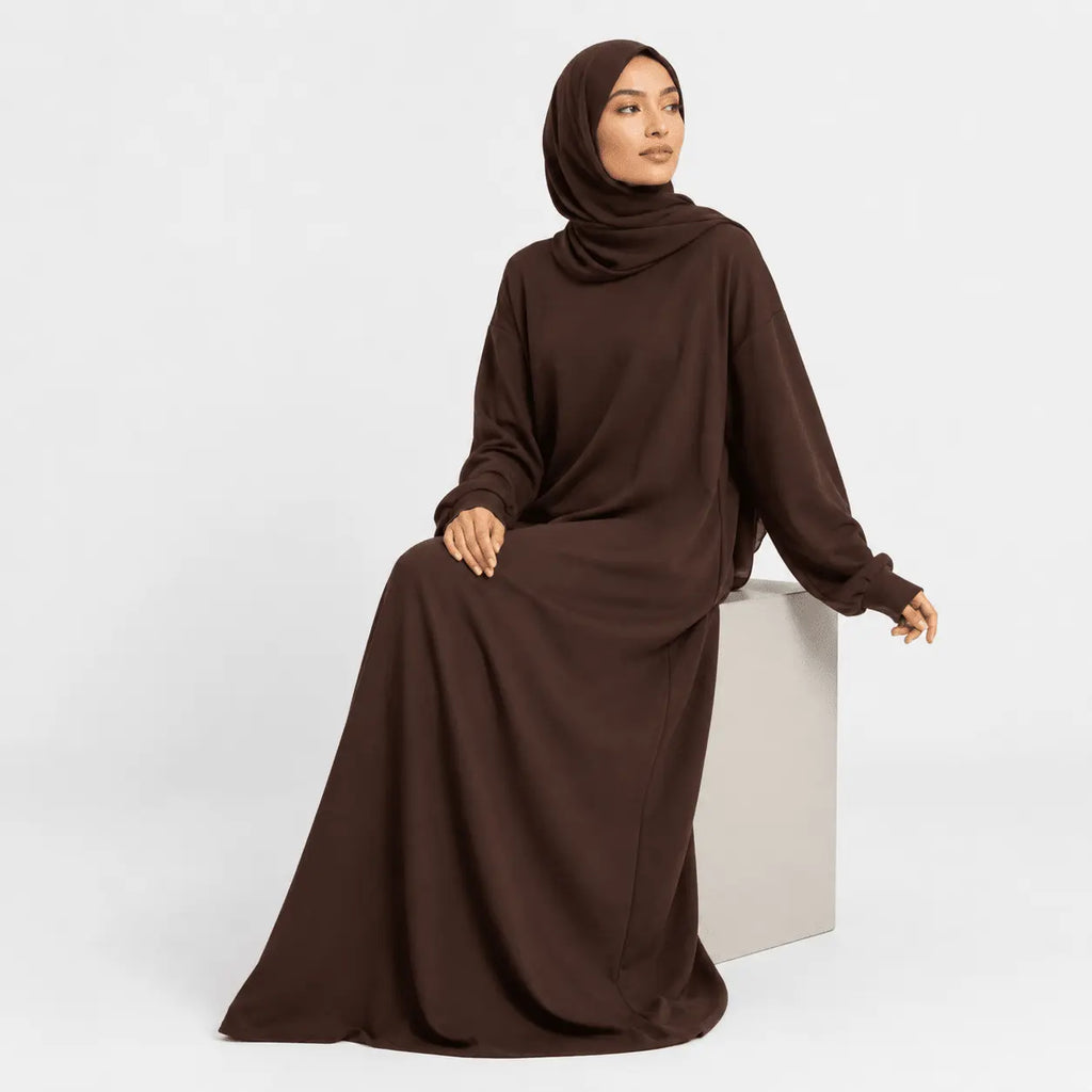 Woman wearing a brown abaya on a white background