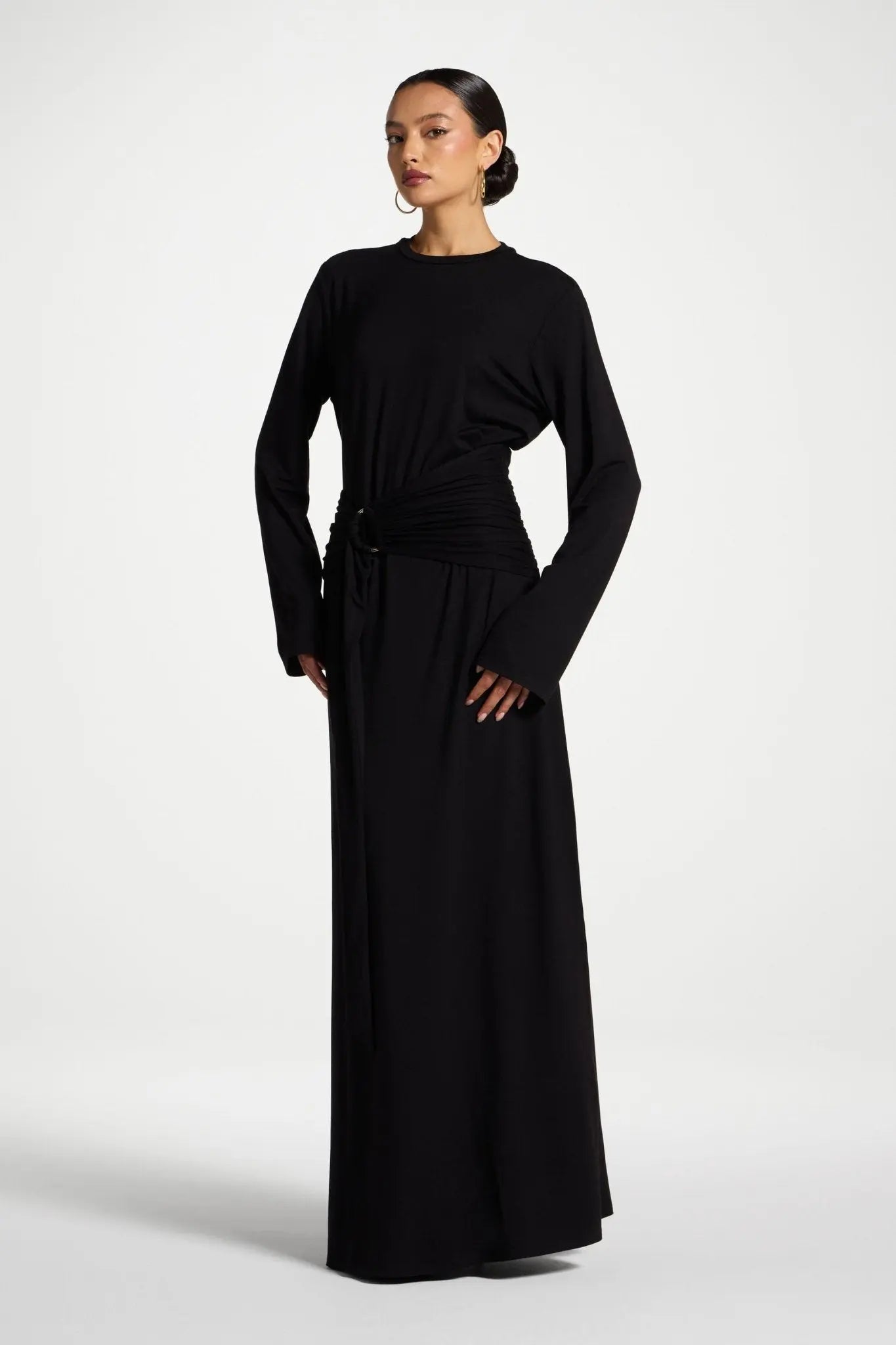 Woman wearing a black long-sleeve dress on a white background