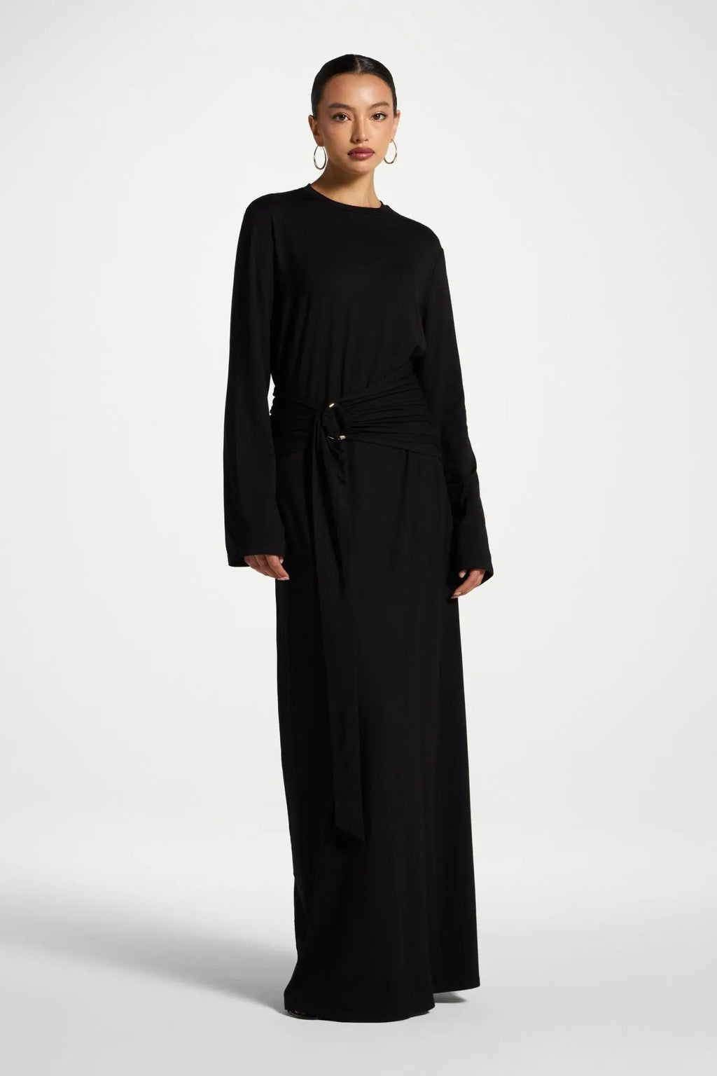 Woman wearing a long black dress on a white background