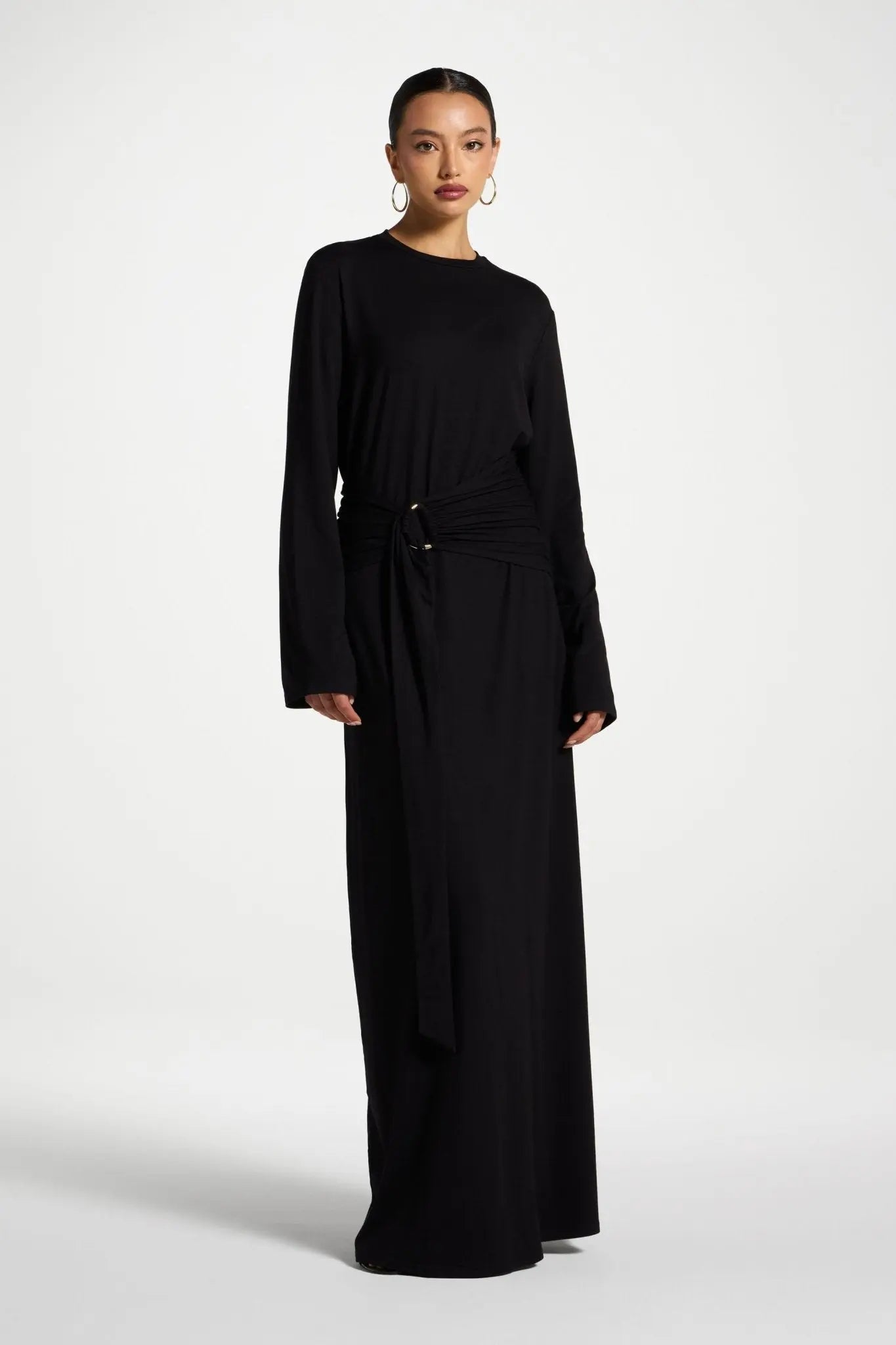 Woman wearing a long black dress on a white background
