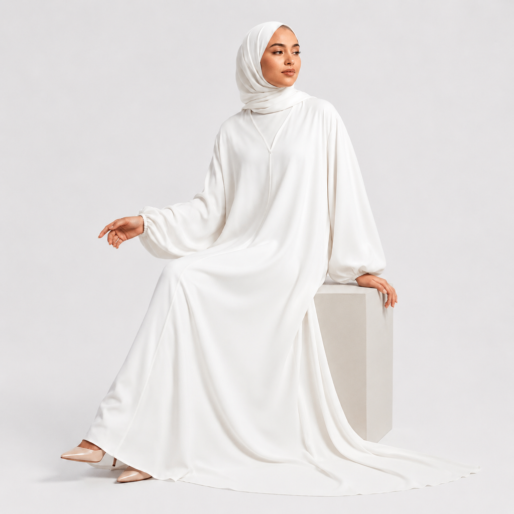 Woman wearing a white abaya on a light gray background