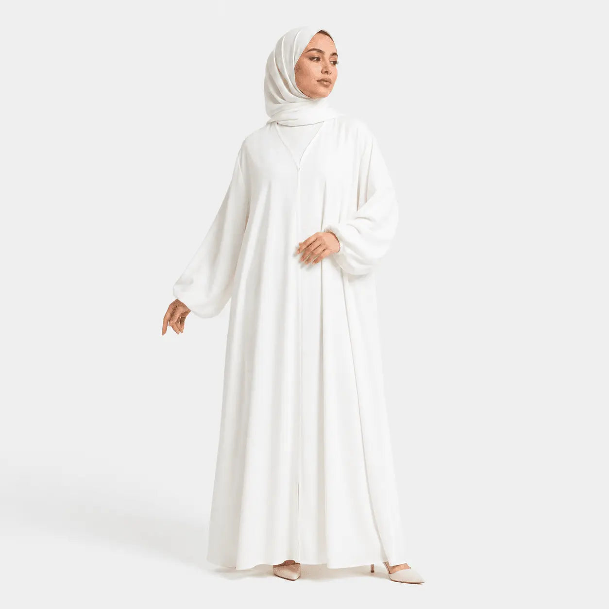 Woman wearing a white abaya and hijab on a white background