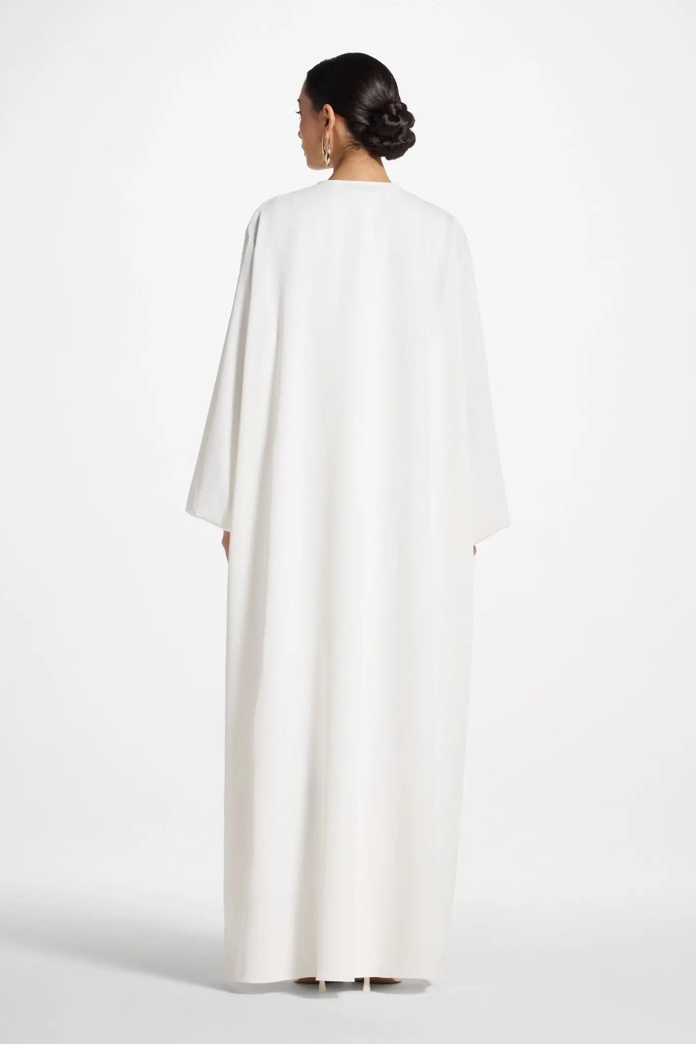 Woman wearing a white cape on a white background