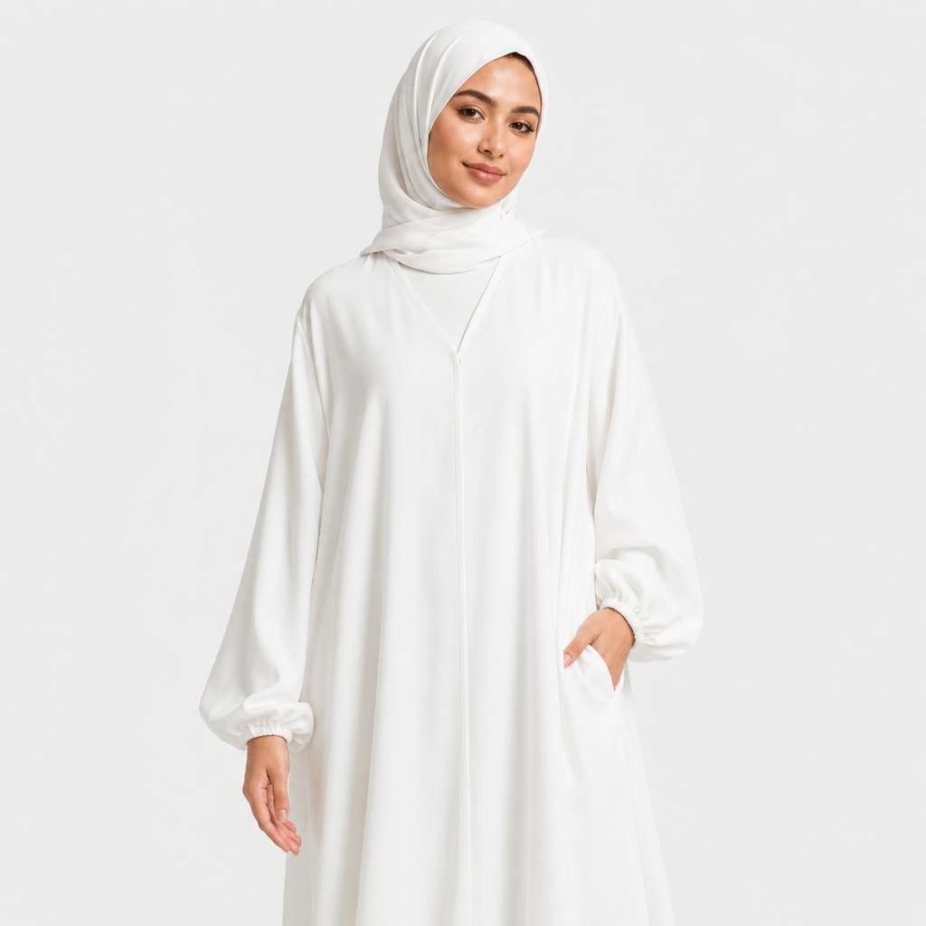 Woman wearing a white abaya on a light gray background