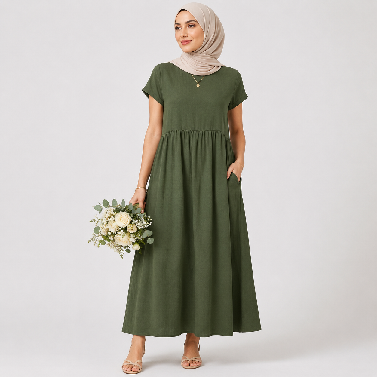 Woman wearing a green dress holding flowers against a white background