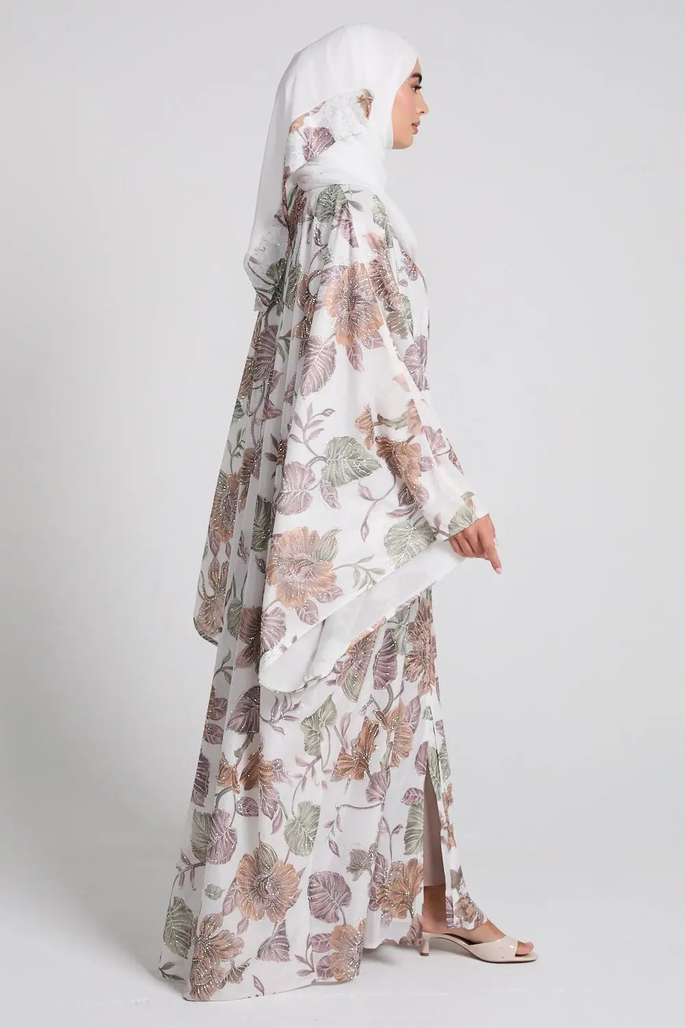 Woman wearing a floral abaya on a white background