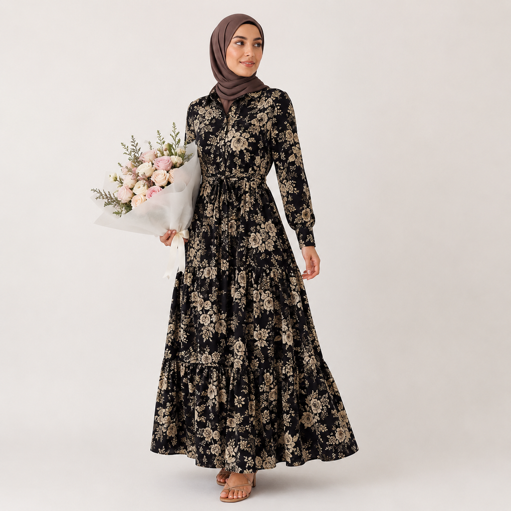 Woman wearing a black floral dress holding flowers against a white background