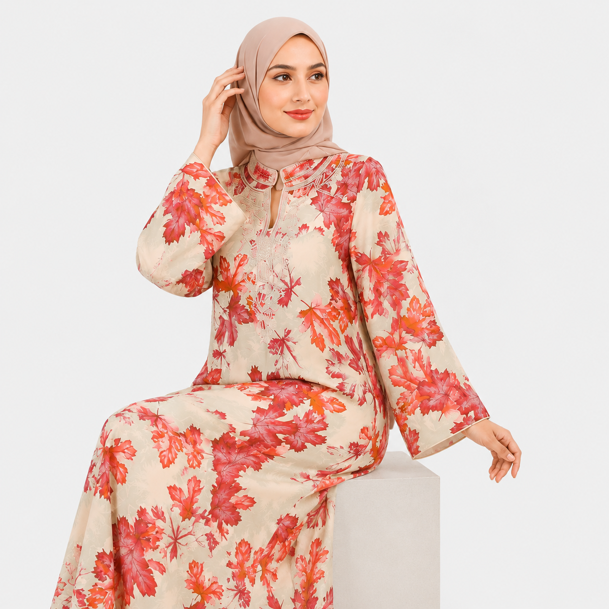 Woman wearing a floral dress with a beige hijab on a white background