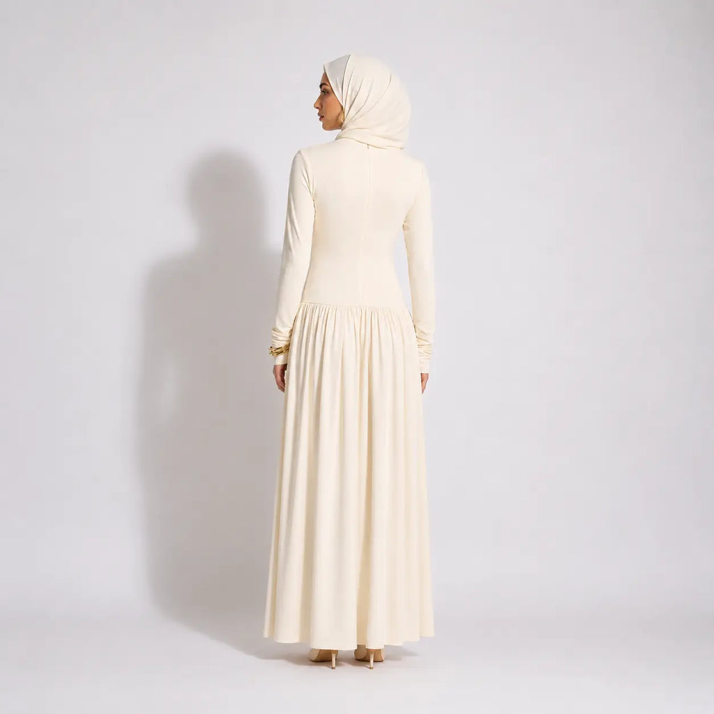 Cream long-sleeve modest dress with pleated skirt and matching hijab, back view