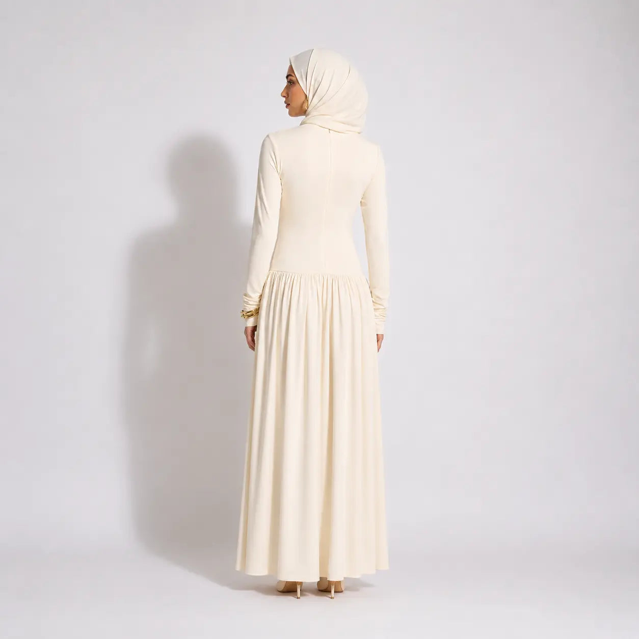 Cream long-sleeve modest dress with pleated skirt and matching hijab, back view