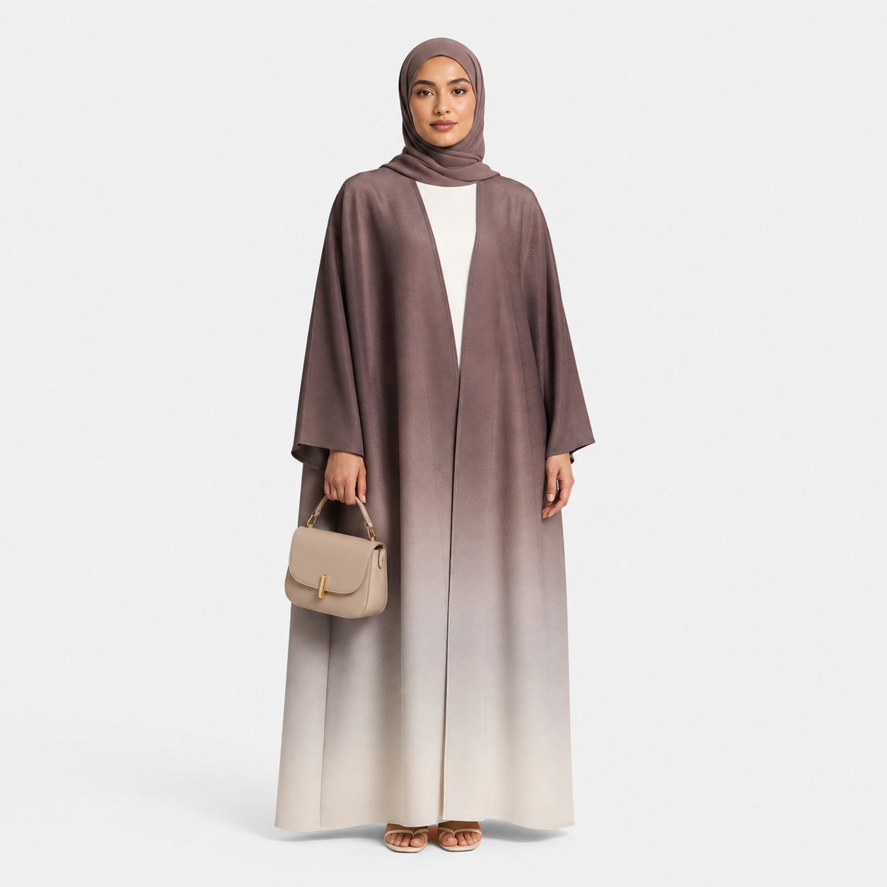 Woman wearing a long, gradient abaya with a matching hijab on a white background