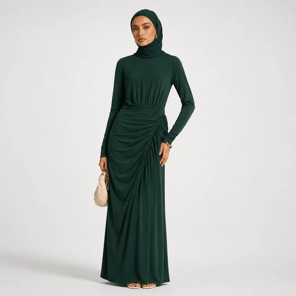 Woman wearing a dark green long-sleeve dress with a hood on a white background
