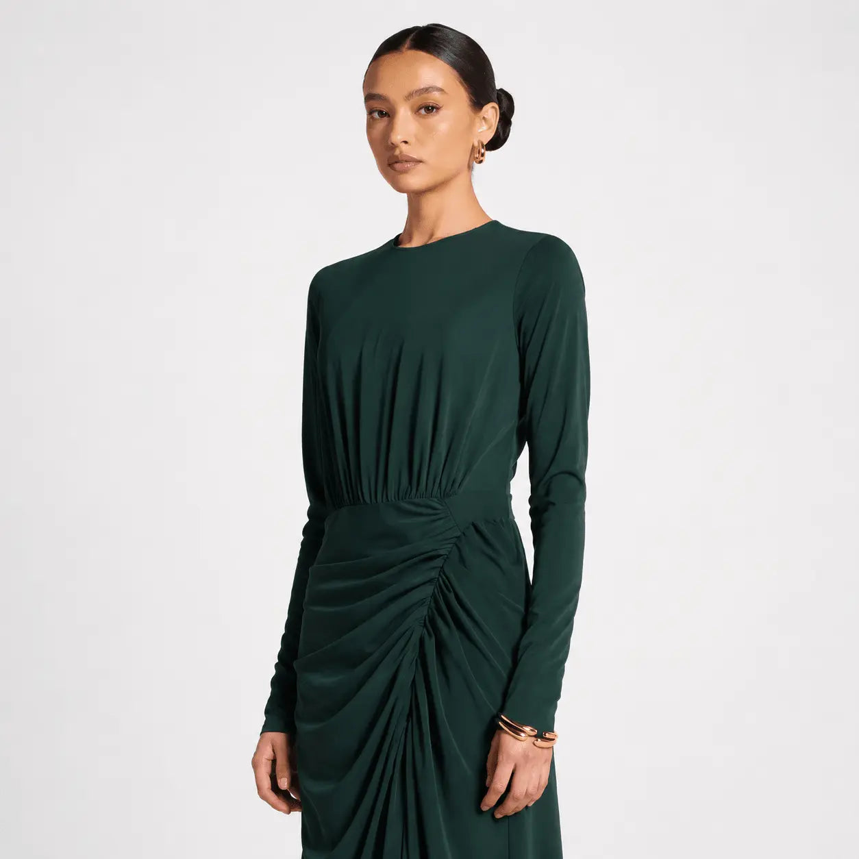 Woman wearing a green dress with a knot detail on a white background