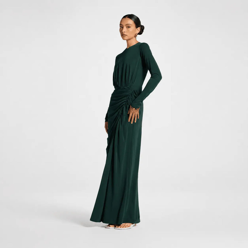 Woman wearing a dark green long-sleeve dress on a white background
