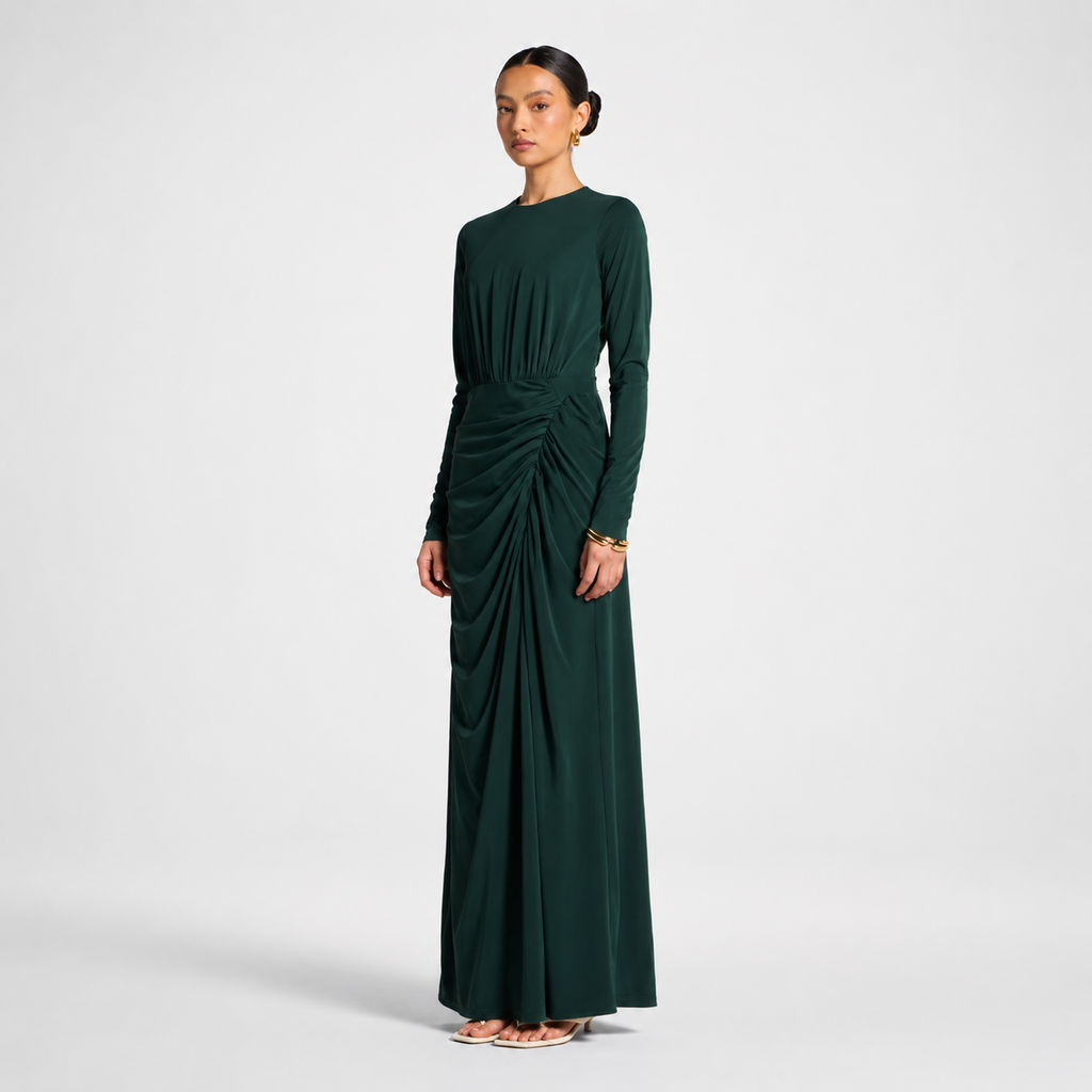 Woman wearing a dark green dress with a draped design on a light gray background